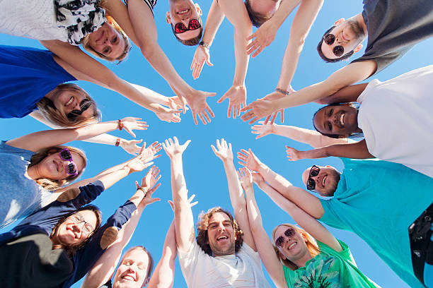 istock Young people raising hands and looking at camera 478394564