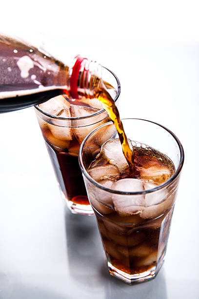istock Cola is pouring into glass on white background 478395914