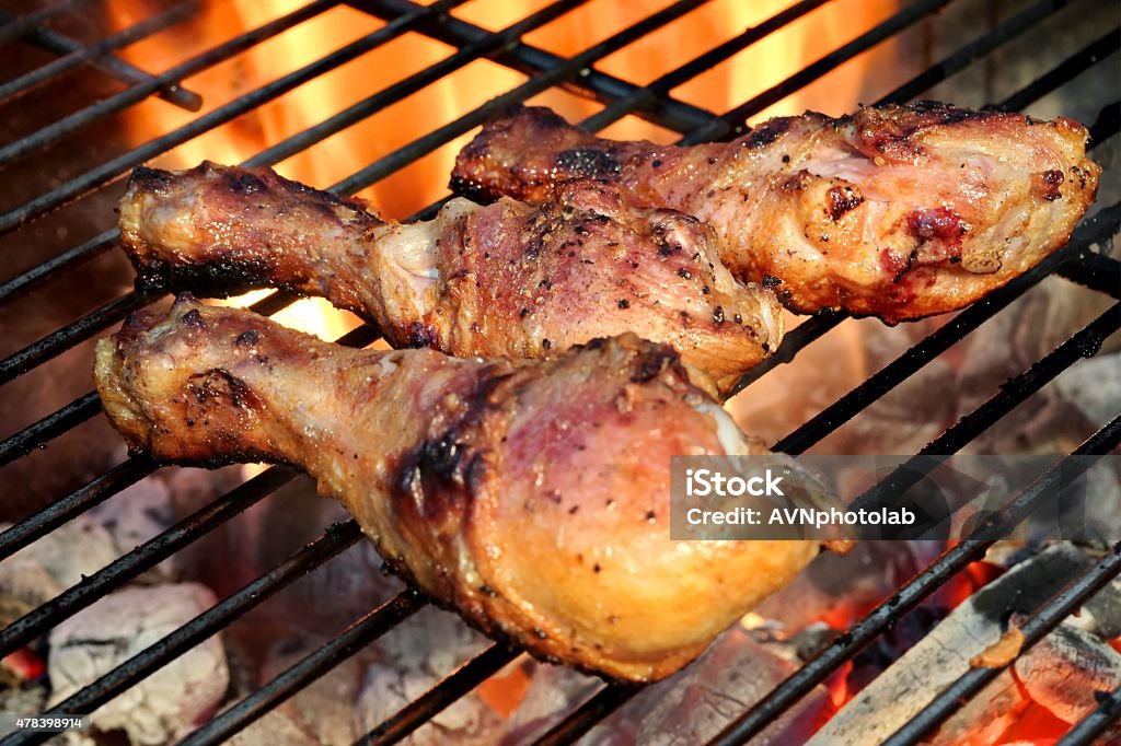 Close-up Of BBQ Chicken Legs On The Hot Flaming Grill Close-up Of BBQ Chicken Legs On The Hot Flaming Charcoal Grill In The Background 2015 Stock Photo