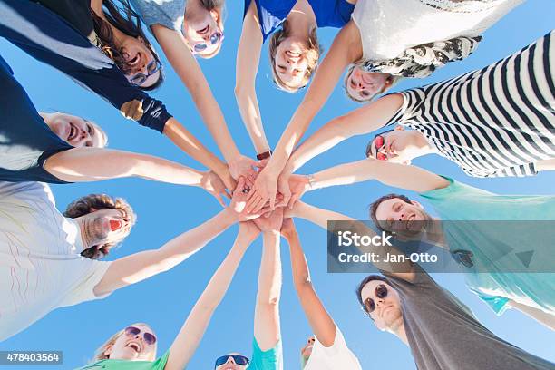 Young People Holding Hands Together Stock Photo - Download Image Now - Circle, Discussion, Hands Clasped