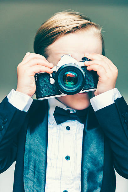 istock Boy takes a photo using an old retro camera 478403966