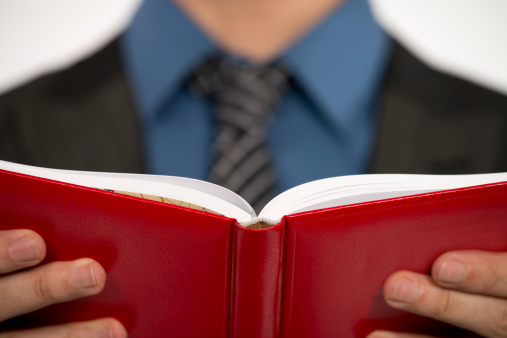 male student holding a book in the library