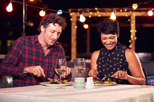 istock Couple eating dinner at rooftop restuarant 478406840