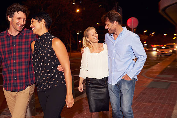 istock Two couples walking through town together at night 478406884