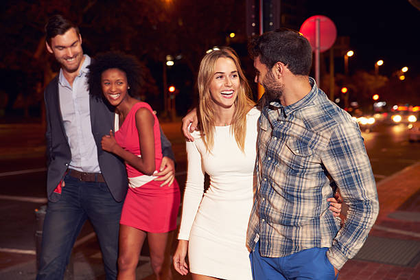 istock Two couples walking through town together at night 478406890