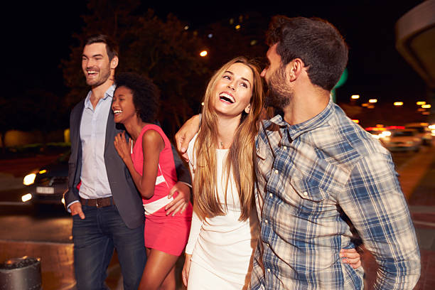 istock Four friends walking through town together at night 478406894