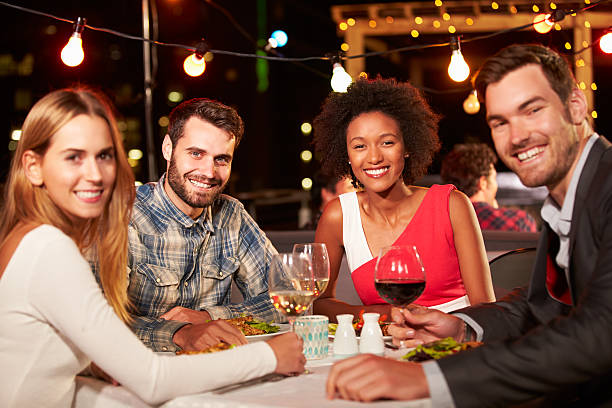 istock Four friends eating dinner at rooftop restaurant 478406976