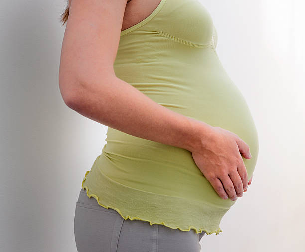 istock smiling pregnant woman touching her belly 478407338