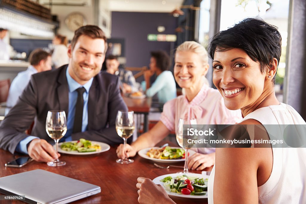 Group of business people at lunch in a restaurant Group of business people at lunch in a restaurant, smiling to camera Business Lunch Stock Photo