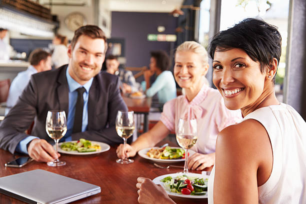 Group of business people at lunch in a restaurant Group of business people at lunch in a restaurant, smiling to camera business lunch stock pictures, royalty-free photos & images