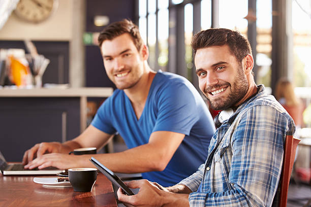 istock Two young men working on computers at a coffee shop 478407656