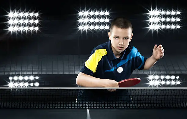 Portrait Of Kid Playing Tennis On Black Background