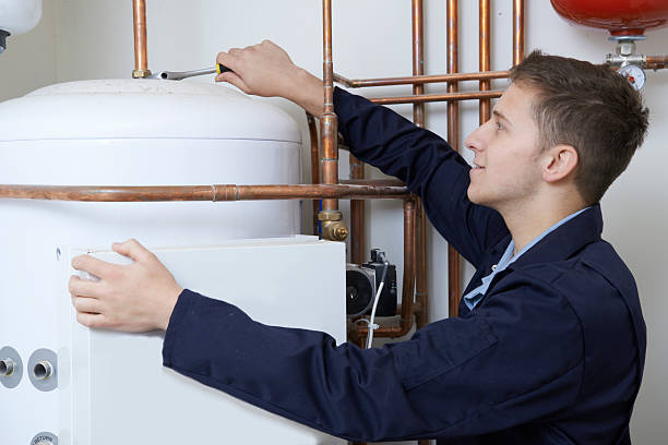 мужской сантехник действовать в центральное отопление водонагреватель - plumber water heater boiler learning стоковые фото и изображения