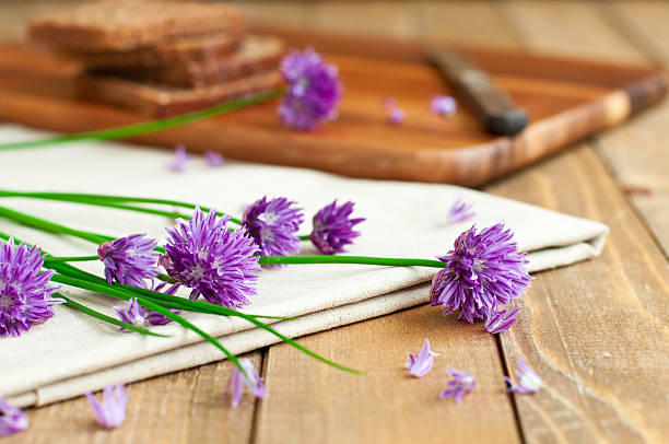 bread with fresh chives Fresh chives and organic rye bread in background, selective focus chives allium schoenoprasum purple flowers and leaves stock pictures, royalty-free photos & images
