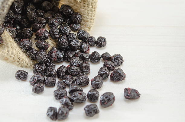 Aronia falling out of a vintage bag on white background