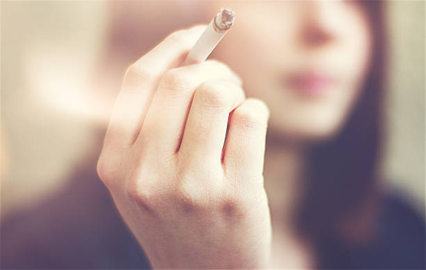 Woman hands holding cigarette outdoor. stock photo