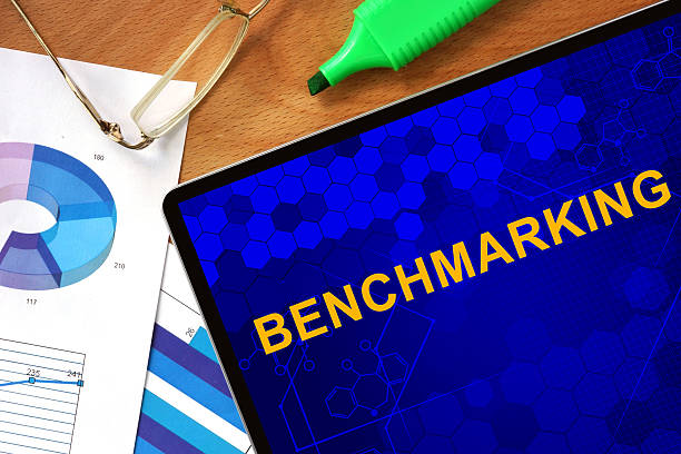 istock Tablet with Benchmarking and charts on a wooden board. 478417764