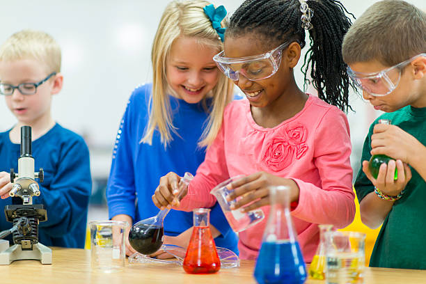 Science Class Elementary school students working on science experiments. food coloring stock pictures, royalty-free photos & images