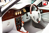 Interior of luxury sports car with white leather and wood