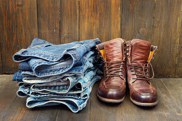 istock Shoes and stack of jeans on wooden background 478426076
