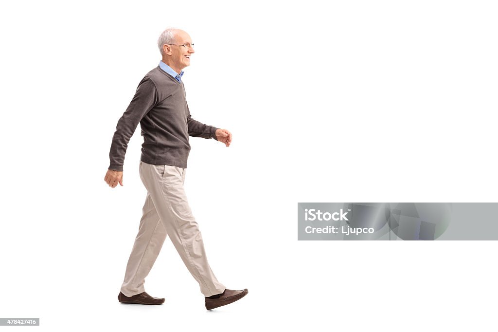 Casual senior man walking and smiling Full length profile shot of a casual senior man walking and smiling isolated on white background Walking Stock Photo