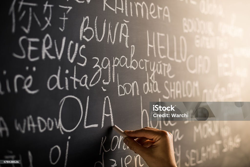 Hello in many languages Hello in many languages written with chalk on blackboard Translation Stock Photo