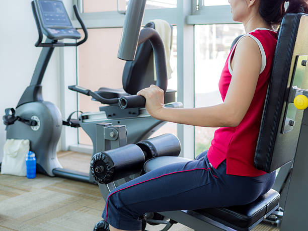 istock Woman exercising with machine in gym 478442780