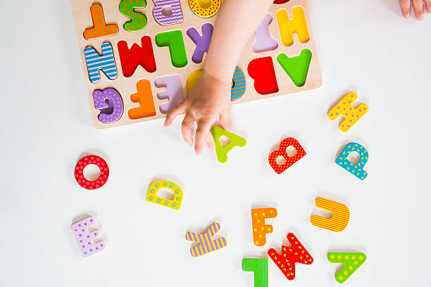 istock Education, child's hands sorting colorful letters in alphabet puzzle 478444056