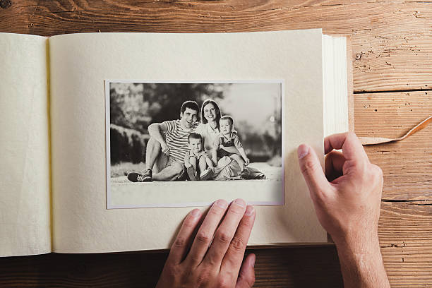 Fathers day composition Fathers day composition - photo album with a black and white photo. Studio shot on wooden background. family photos album stock pictures, royalty-free photos & images