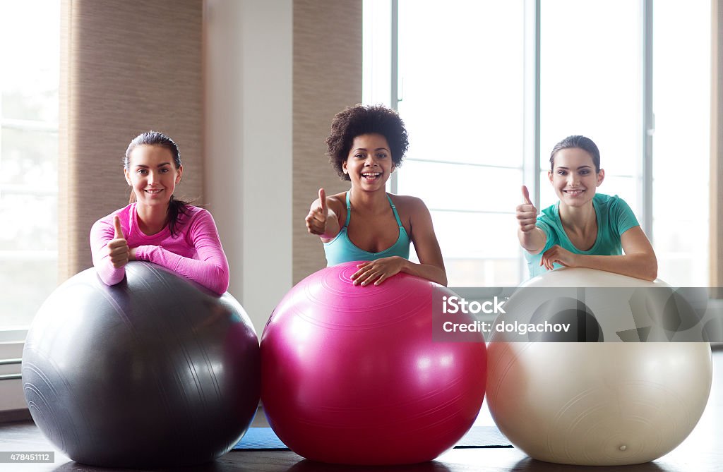 group of smiling women with exercise balls in gym fitness, sport, training and lifestyle concept - group of smiling women with exercise balls in gym 2015 Stock Photo