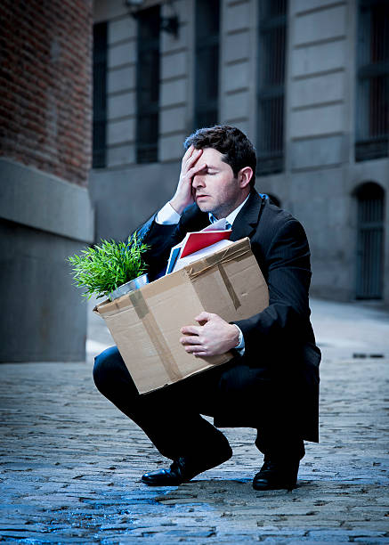 istock frustrated business man on street fired with cardboard box 478455727
