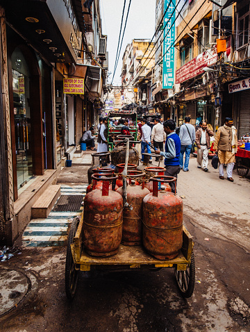 Old Delhi, India - March 3, 2015: Propane tanks on a wooden cart, which is a common way to transport all kinds of merchandise. People are also visible in the image.