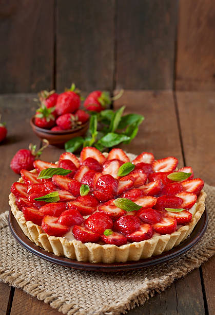 torte mit erdbeeren und schlagsahne mit minzblättern verziert - strawberry tart stock-fotos und bilder