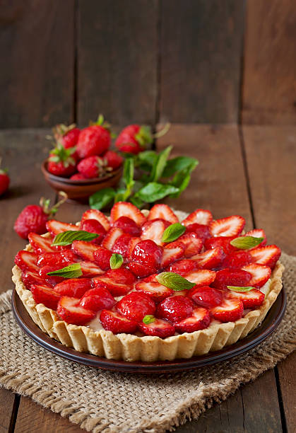 тарт с клубникой и взбитые сливки оформлены с листьями мяты - strawberry tart стоковые фото и изображения