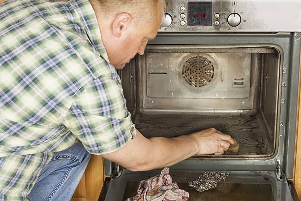 istock Man in the kitchen and cleans the oven. 478459292