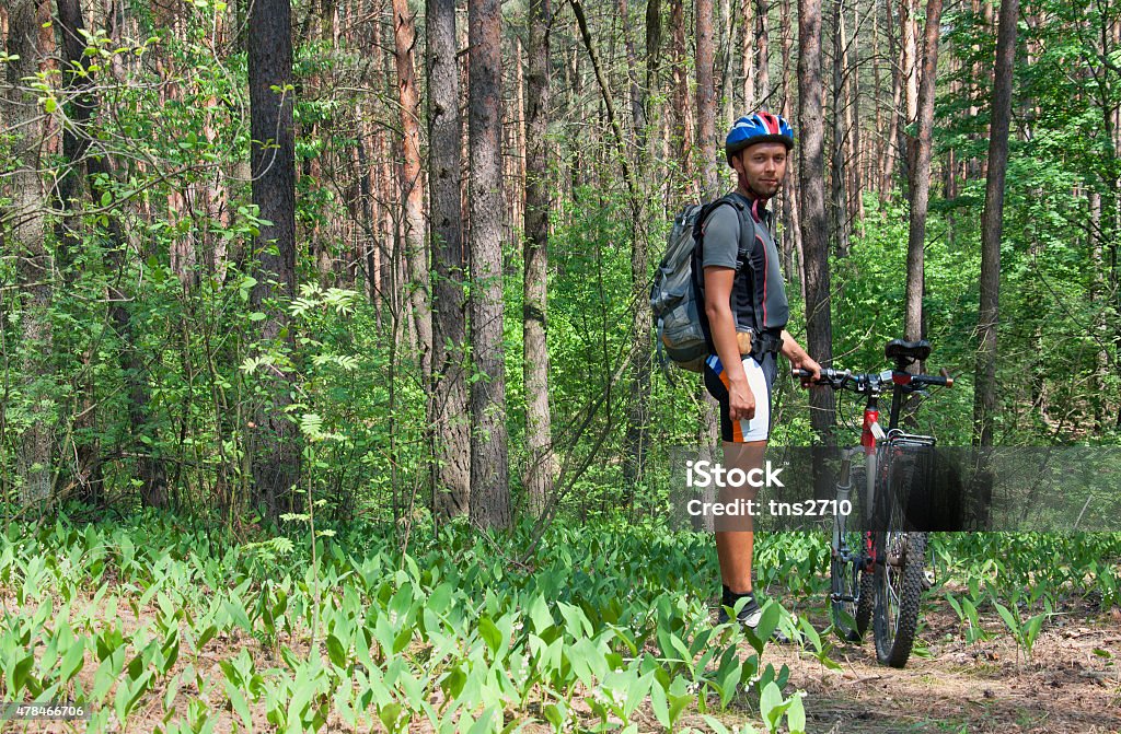 Young man standing in the forest Young man standing in the forest posing proudly with his ATB bike 2015 Stock Photo