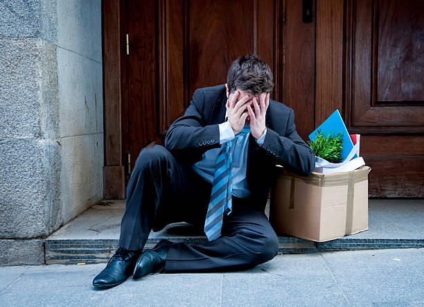 istock frustrated business man on street fired carrying cardboard box 478467135