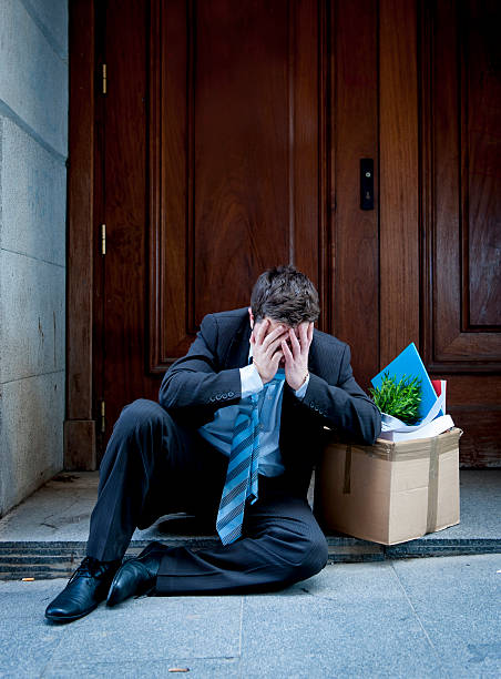 istock frustrated business man on street fired carrying cardboard box 478467149