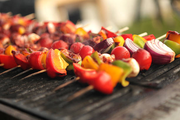 Kebabs of Mixed vegetables on a barbecue. Kebab s on sticks cooking on a barbecue containing meat and mixed peppers. griddle stock pictures, royalty-free photos & images