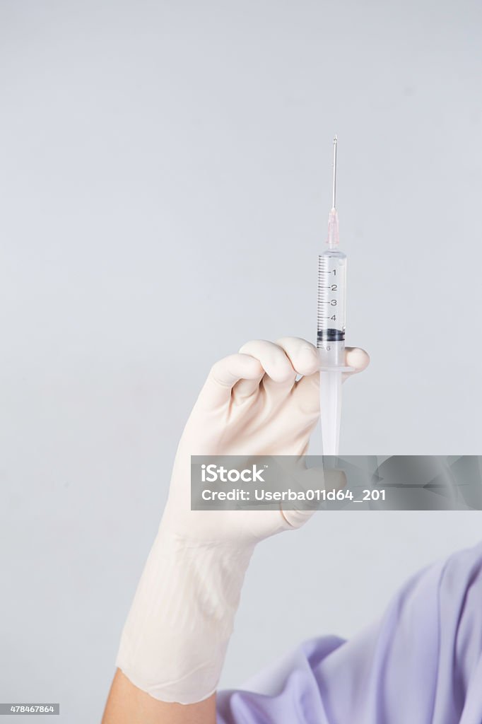 Doctor's hands holding syringe closeup on white background 2015 Stock Photo