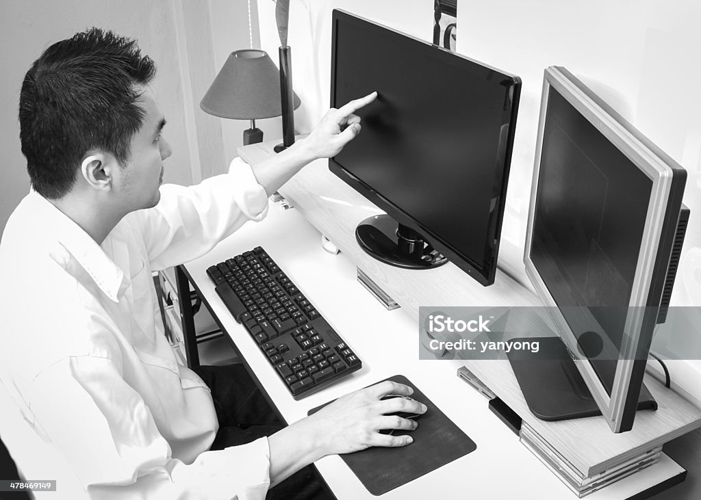Asian businessman work in front of dual monitors computer Asian businessman work in front of dual monitors computer and touch screen B&W Adult Stock Photo