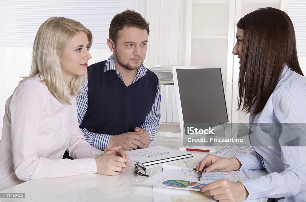 Young attractive couple at consultation with female consultant. Consultation at office with young couple and female consultant. Adult Stock Photo