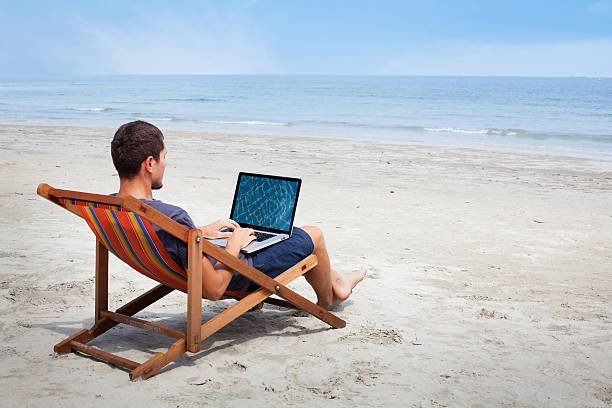 istock man with laptop on the beach 478469818