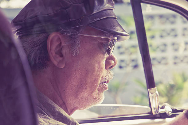 istock Older man with glasses driving a car 478475420