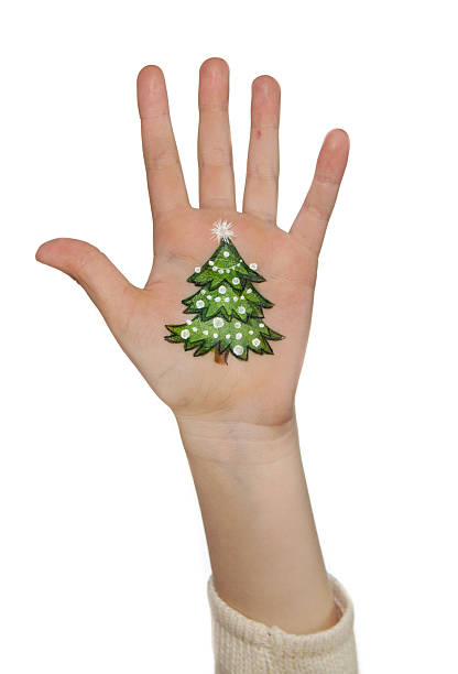 istock Kid's hands with painted Christmas symbol. xmas tree 478476354