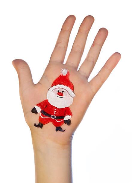 Kid's hands with painted Christmas symbol. Santa