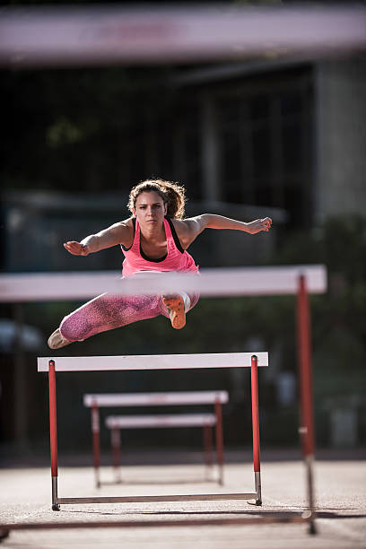 sportowca określić kobieta skoki przez płotki w wyścigu. - hurdling hurdle competition endurance zdjęcia i obrazy z banku zdjęć