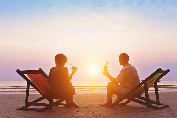 romantic holidays family enjoying romantic sunset on the beach luxury hotel stock pictures, royalty-free photos & images