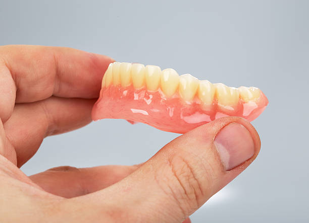 istock Hand holding a set of dentures 478479673