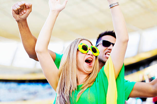 istock Soccer-supporting couple cheer and wave their arms enthusiastically 478482401